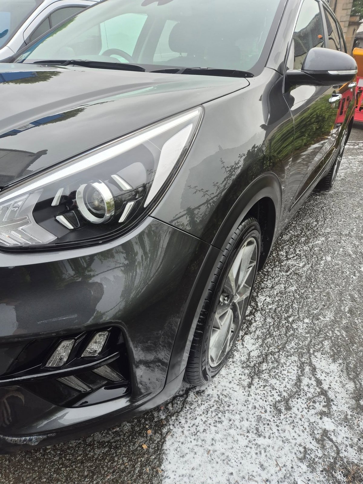 Front end of a dark grey car with clean paintwork and grille after valeting